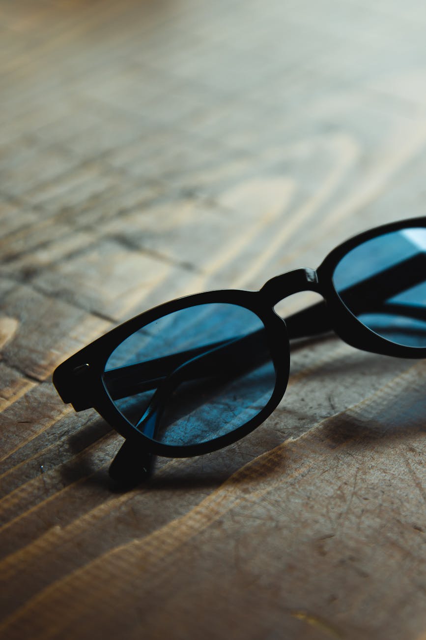 stylish sunglasses placed on wooden table